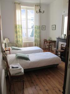 1 dormitorio con 2 camas, mesa y ventana en Chambre d'Hôtes Marchand, en Angers