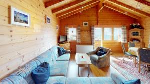 a living room with a blue couch in a log cabin at Danica in Blatten bei Naters