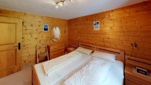a bedroom with a bed in a wooden room at Danica in Blatten bei Naters