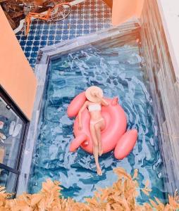 uma estatueta de plástico de uma pessoa numa jangada numa piscina em Rosie Villa Hội An em Hoi An