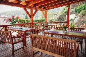 un patio con mesas y sillas en una terraza de madera en Hotel Stein Elbogen en Loket