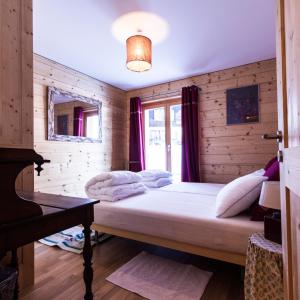 a bedroom with a bed in a wooden wall at Chalet Magrappe by Swiss Alps Village in Veysonnaz