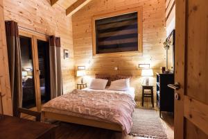ein Schlafzimmer mit einem Bett in einer Holzhütte in der Unterkunft Chalet Magrappe by Swiss Alps Village in Veysonnaz