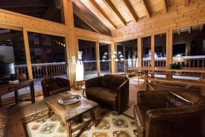 a living room with chairs and a table in a cabin at Chalet Magrappe by Swiss Alps Village in Veysonnaz