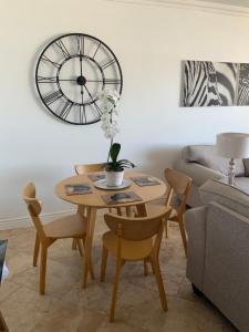 a living room with a table and a clock on the wall at 702 Oyster Schelles in Durban