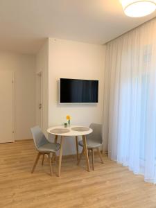 a dining room with a table and chairs and a tv at COZY Nest apartment in Kaunas in Kaunas