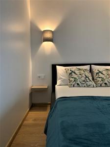 1 dormitorio con 1 cama y una luz en la pared en COZY Nest apartment in Kaunas, en Kaunas