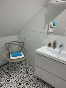 a bathroom with a chair next to a sink at COZY Nest apartment in Kaunas in Kaunas