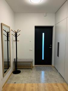 a room with a black door with a bench in front at COZY Nest apartment in Kaunas in Kaunas