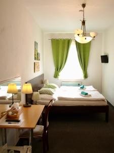 カルロヴィ・ヴァリにあるPension Villageのベッド2台、デスク、窓が備わる客室です。