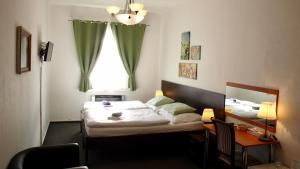 1 dormitorio con cama, escritorio y ventana en Pension Village, en Karlovy Vary