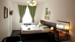 a bedroom with a bed and a desk and a window at Pension Village in Karlovy Vary