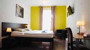 a bedroom with a bed and a desk and a window at Pension Village in Karlovy Vary