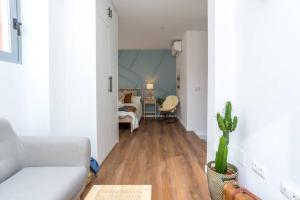 ein Wohnzimmer mit einem weißen Sofa und einem Kaktus in der Unterkunft TGH/ Málaga center western style in Málaga