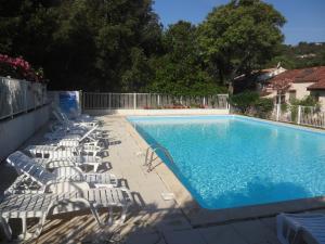 a swimming pool with chaise lounge chairs next to it at Residence Pezza Cardo in Porto-Vecchio