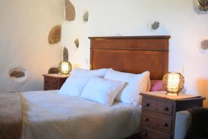 a bedroom with a bed with two lamps on tables at Finca Mariola - Alpendre in San Bartolomé