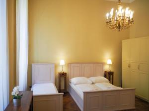 une chambre avec deux lits et un lustre dans l'établissement Smetanovo nábřeží - Riverview Old Town Apartment, à Prague