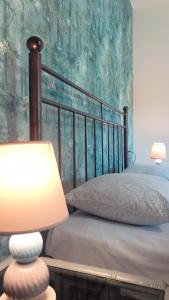 普拉塔利亞的住宿－Armonia Apartment，一间卧室配有一张带灯具和绘画的床