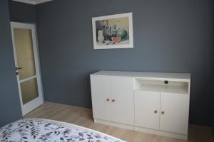 SlušoviceにあるRetro vilaの白いキャビネット付きのベッドルーム1室、壁に絵が描かれています。