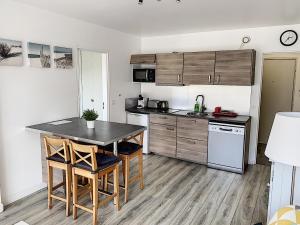 een keuken met een tafel en stoelen in een kamer bij 2 PIECES CENTRE ET MER in Cabourg