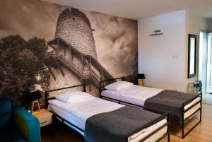 2 łóżka w pokoju z malowidłem ściennym w obiekcie Hotel Spichlerz Pierwszy SPA & WELLNESS w Kazimierzu Dolnym