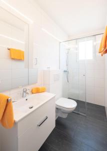 a white bathroom with a toilet and a shower at Pension Helios in Sankt Kanzian