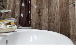La salle de bains est pourvue d'une baignoire blanche et d'un lavabo. dans l'établissement K&K Beach Luxury, à Bourgas