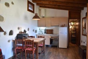 eine Küche mit einem Tisch und Stühlen sowie einem Kühlschrank in der Unterkunft Finca Mariola - Alpendre in San Bartolomé de Tirajana