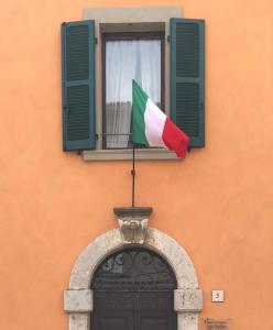 a flag on top of a building with a window at B&B Dimora Paolina in Baschi