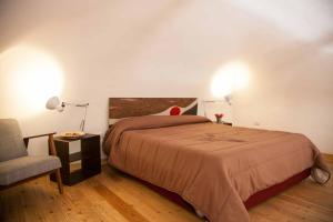 a bedroom with a large bed and a chair at Naturalmente abitare in Catania