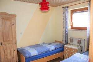 a small bedroom with a bed and a window at Ferienwohnungen Irene Konstandin in Bischofsmais