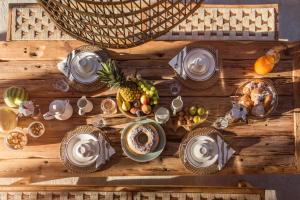 une table en bois avec des fruits et des assiettes de nourriture dans l'établissement B&B Giallo Limone, à Teulada