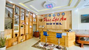 un vestíbulo con paredes de madera y taburetes azules en Khách sạn Phúc Lộc An Côn Đảo, en Con Dao