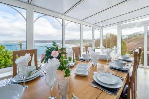 a dining room with a table with a view of the ocean at Adanac in Sennen Cove