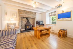 a living room with a couch and a fireplace at Adanac in Sennen Cove