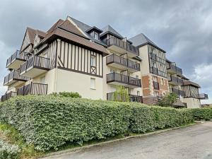 a building with balconies on the side of a street at FRONT DE MER 11 - JARDIN - THALASSO in Cabourg