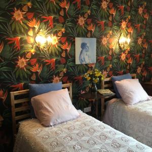 a bedroom with two beds and a floral wallpaper at Chambres d Hôtes Les Filles Tresy in Passenans