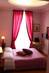 a bedroom with a large window with red curtains at Duca's Guest House in Turin