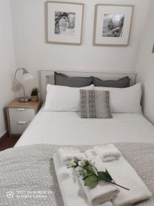 a white bed with towels and flowers on it at Dante's Relais in Florence