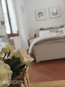 a vase with flowers on a table in a bedroom at Dante's Relais in Florence