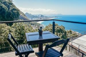 uma mesa e duas cadeiras numa varanda com o oceano em Mirante do Arvrao no Rio de Janeiro