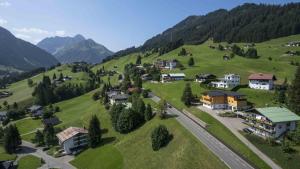 ein kleines Dorf auf einem grünen Hügel mit Häusern in der Unterkunft Ferienwohnung Riezler in Hirschegg