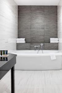 a white bathroom with a tub and a sink at Metropolitan Boutique Hotel in Krakow