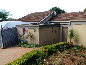 una casa con una puerta y una valla en Love Joy Peace Cottage en Pretoria