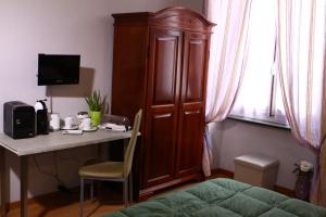 a bedroom with a desk and a cabinet with a computer at Duca's Guest House in Turin