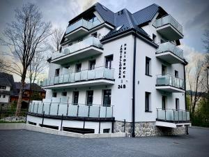 een wit gebouw met balkons aan de zijkant bij CHARDONNAY APARTMENT ZAKOPANE Centrum Jagiellońska Residence in Zakopane