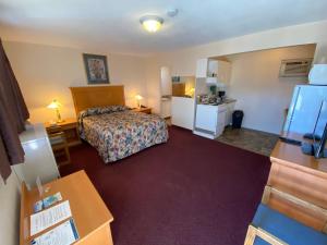 a hotel room with a bed and a kitchen at Silver Star Motel in Vernon