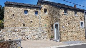 a brick building with a door on the side of it at Un Air de Campagne in Sprimont