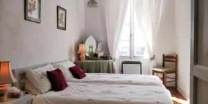 a bedroom with two beds and a table and a window at Les Glycines Bed & Breakfast in Eymet