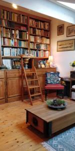 a room with a library with a table and a chair at Les Glycines Bed & Breakfast in Eymet